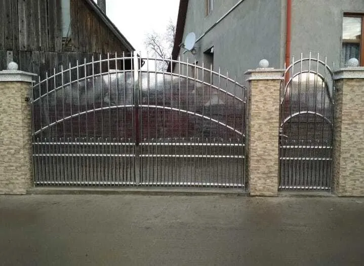 Двустворчатые ворота с арочным верхом и калиткой из нержавеющей стали между кирпичными столбами